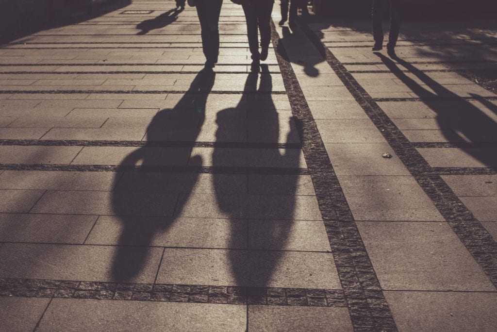 Silhouettes of people walking on city street