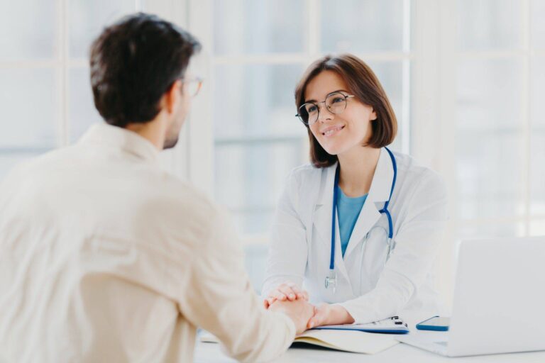 confident female doctor holds hands of ill patient persuades everything will be alright