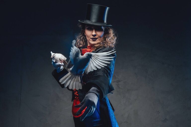 serious female magician with white pigeons and top hat in dark background
