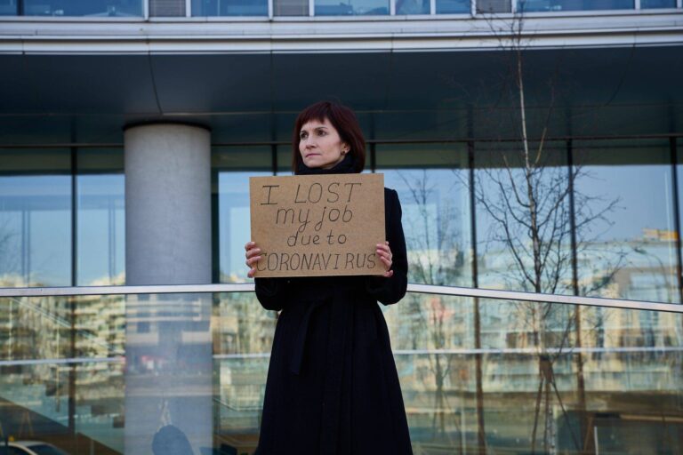 woman holds sign saying i lost my job because of coronavirus 1