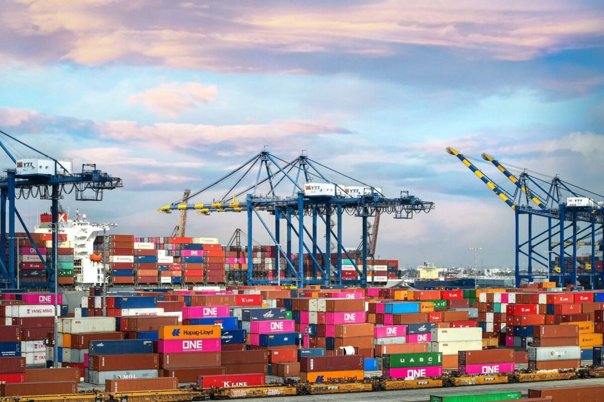 Logistik-Branche: Container werden an einem Hafen mit Kränen angehoben